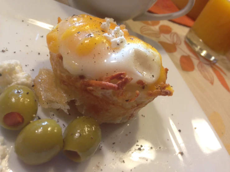 an egg and cheese muffin topped with sour cream and olives