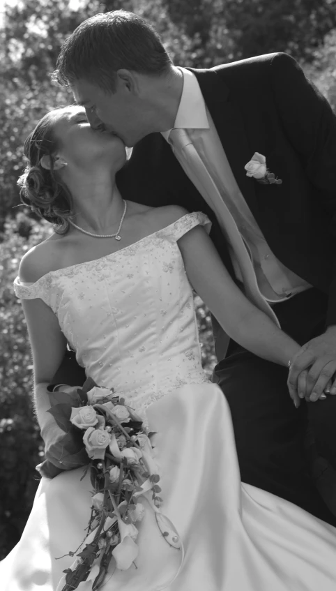 bride and groom kiss on their forehead outside