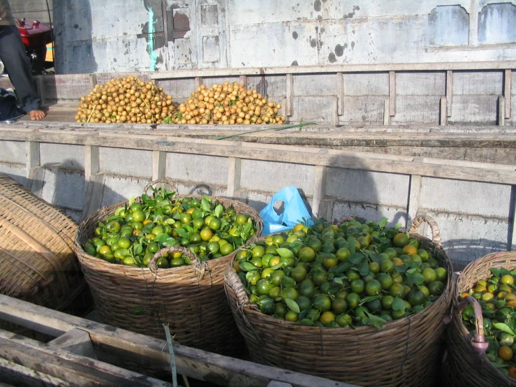 some large baskets filled with green bananas and other fruit