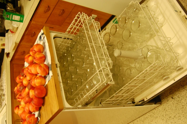 a bunch of peaches sitting on top of a dishwasher