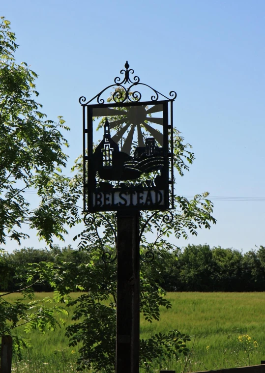 a clock stands in the middle of a field