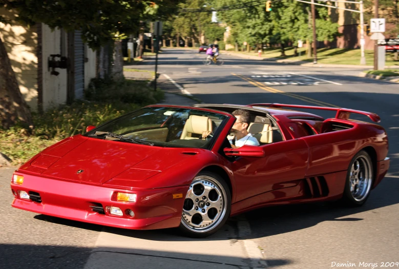 a red sports car parked next to a road