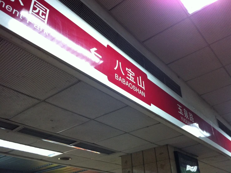 a red and white sign hanging from the side of a wall