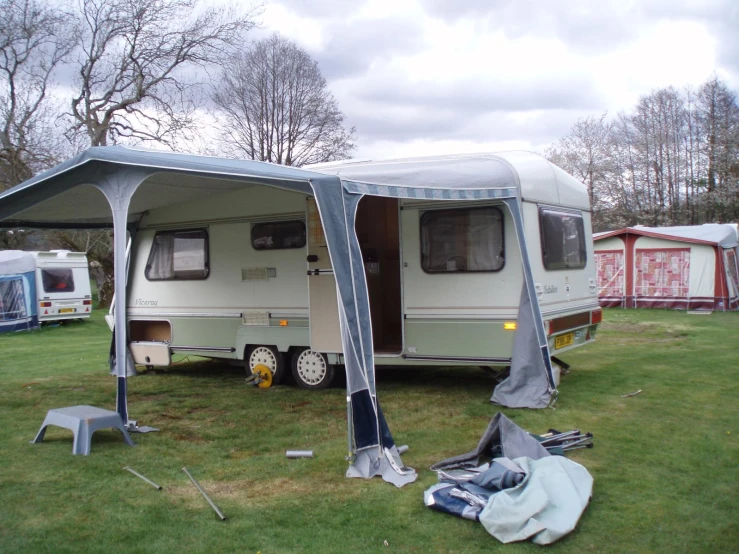 a trailer parked in a green field with a tarp over it