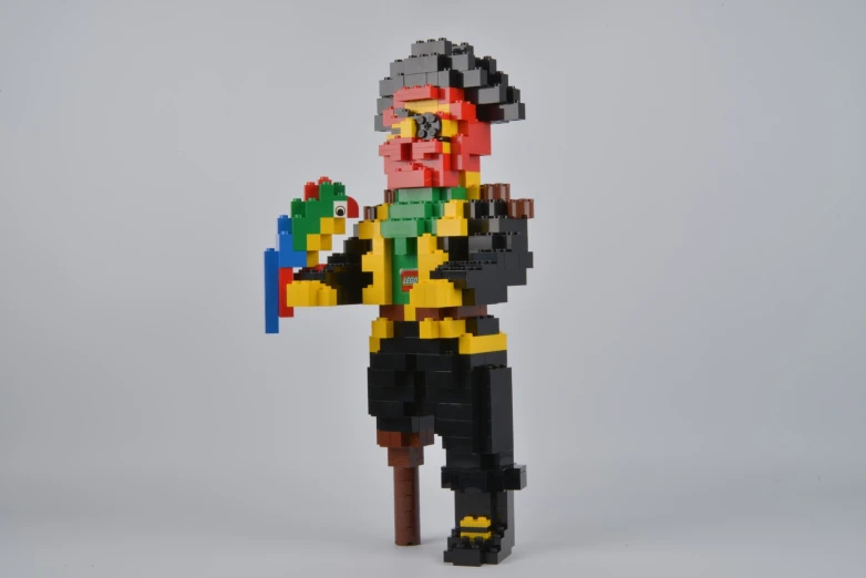 a lego man in a black suit holding an orange, green, yellow and blue piece of plastic