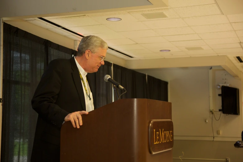 a man in a suit is giving a speech