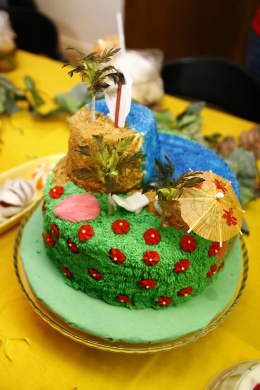 a colorful cake with an umbrella is on a yellow table cloth