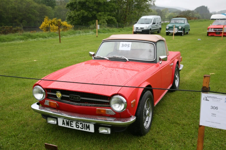 old and new convertible cars are parked on the grass