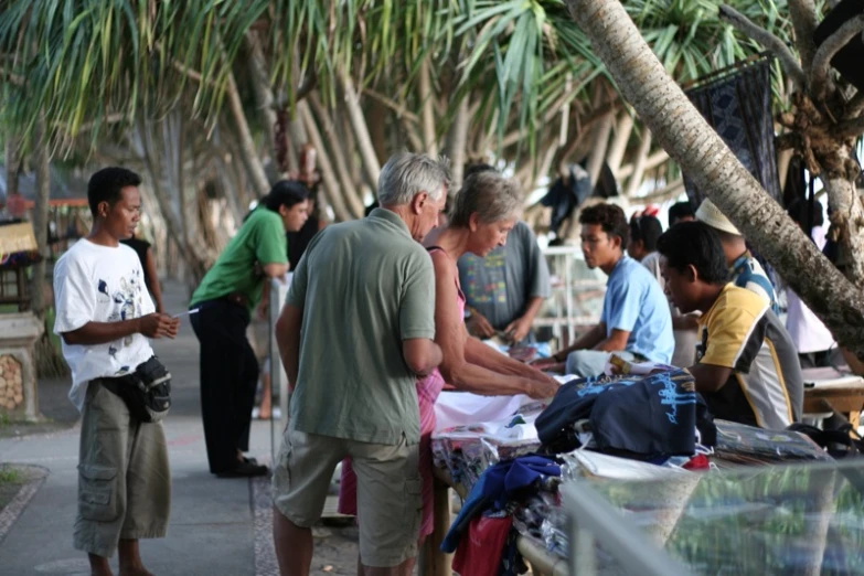 the people are gathered on the side of the street to check out their items