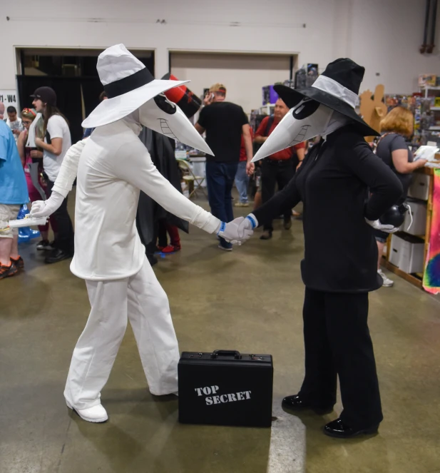 people dressed in fancy costumes holding hands at an exhibition