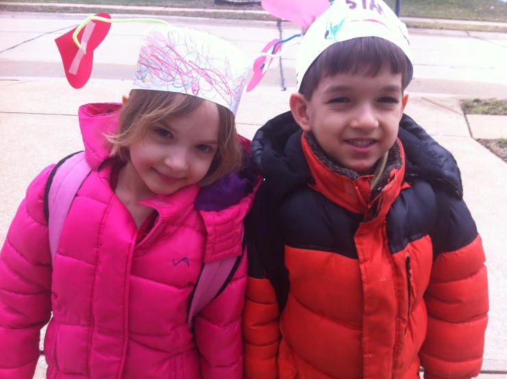 two young children wearing party hats smiling for the camera