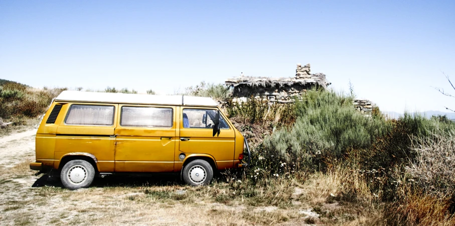 a yellow van parked in the middle of a grassy area