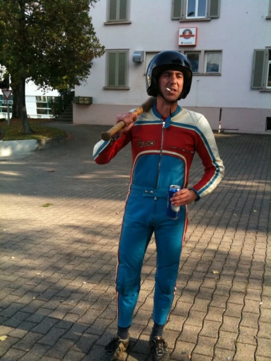 a man in blue and red jumpsuit with a wooden baseball bat