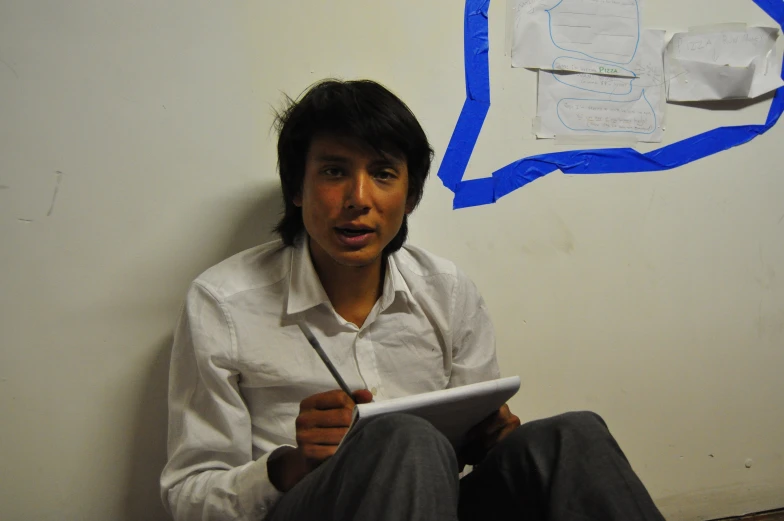 a man holding a paper on the wall using an ipad