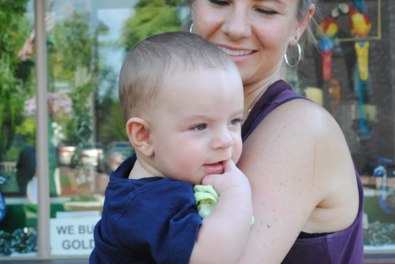 a baby and an adult in a blue shirt