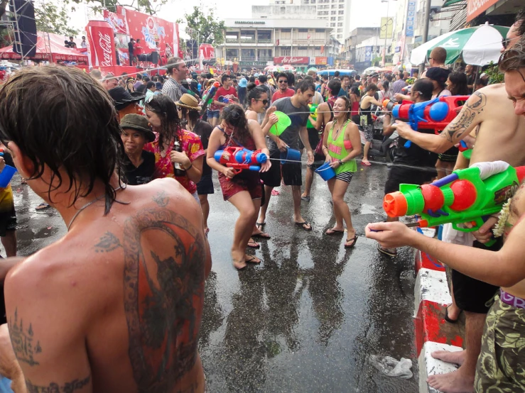 a group of people in the street holding water guns