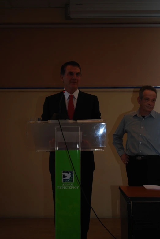 the man stands next to the podium while wearing a suit