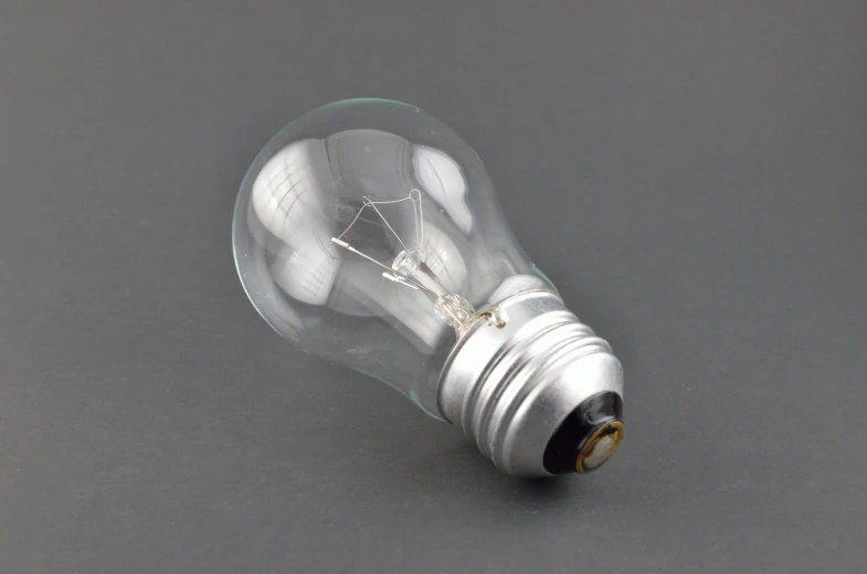 small light bulb on grey table with black background