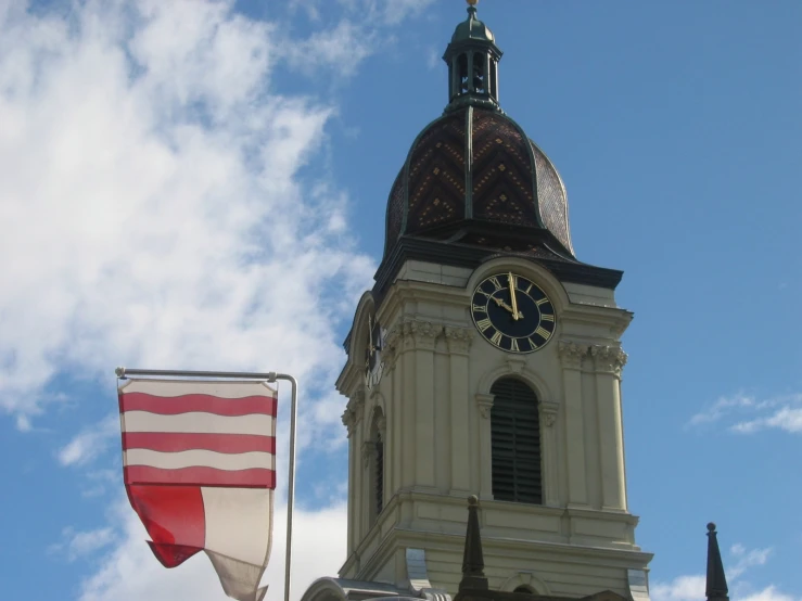 two flags and an american flag in front of a tower