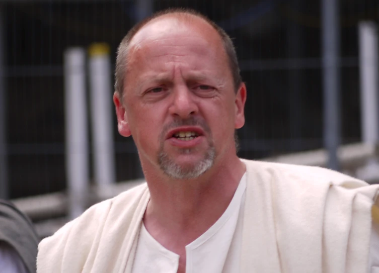 a man dressed in religious clothes looks into the camera