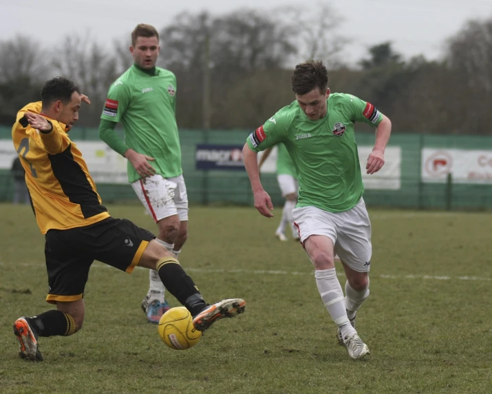 three soccer players in action on the field