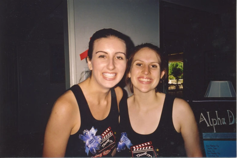 two young women standing next to each other smiling for the camera