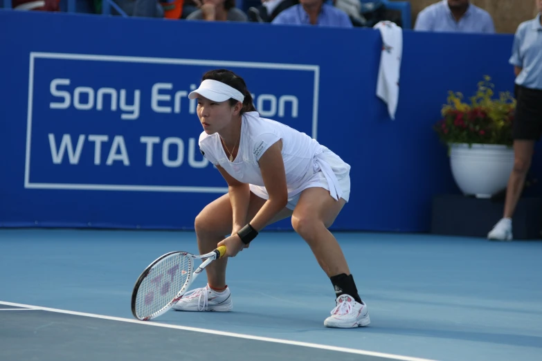 a woman tennis player crouched down on the court