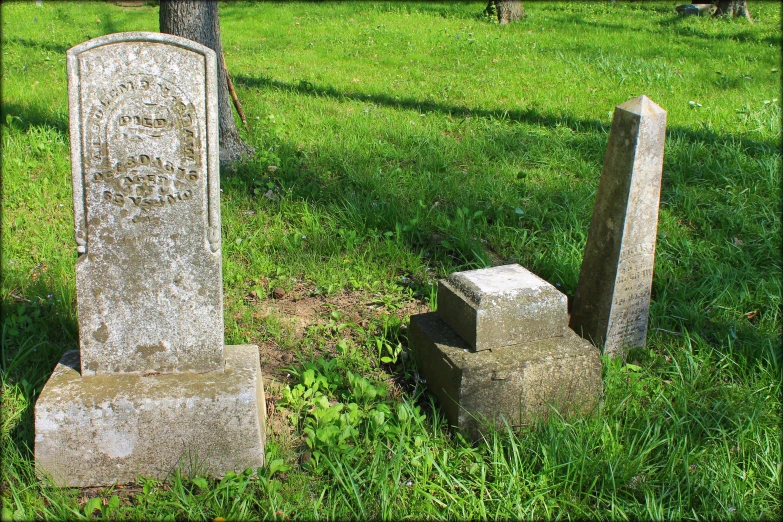 a couple of headstones are in the grass