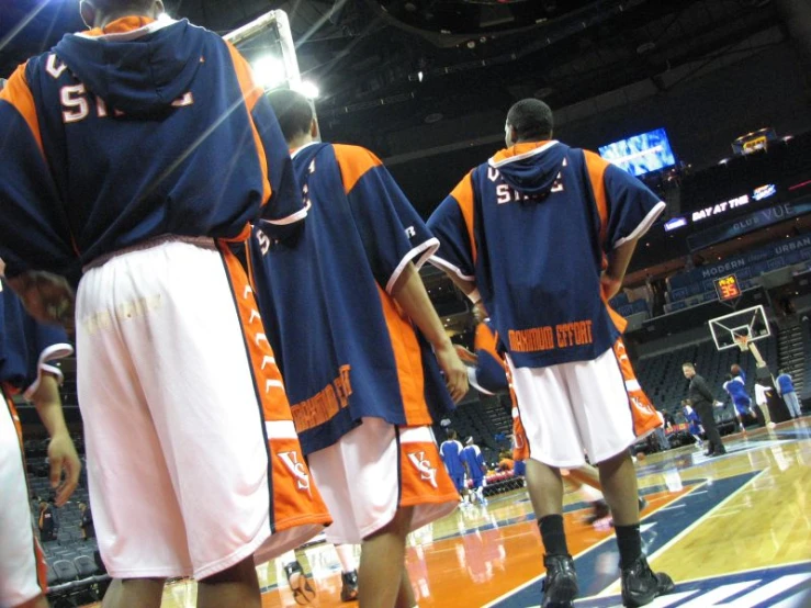 the basketball team is wearing blue and orange uniforms