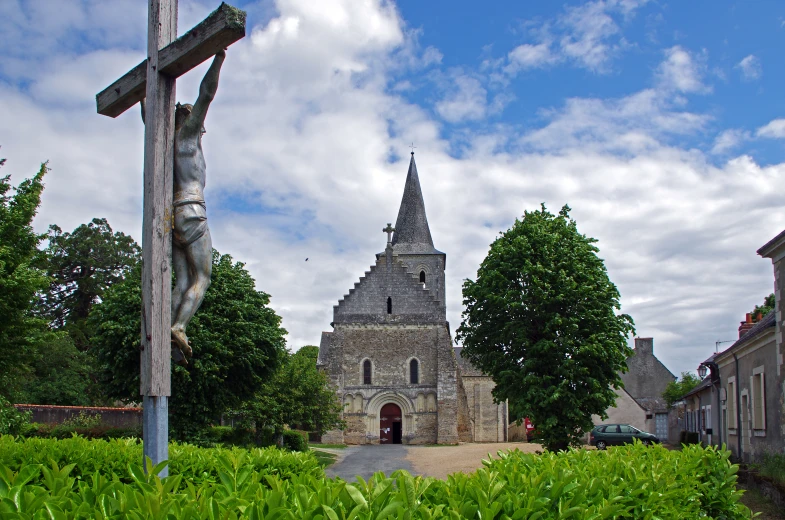 an old church with a tower near some bushes