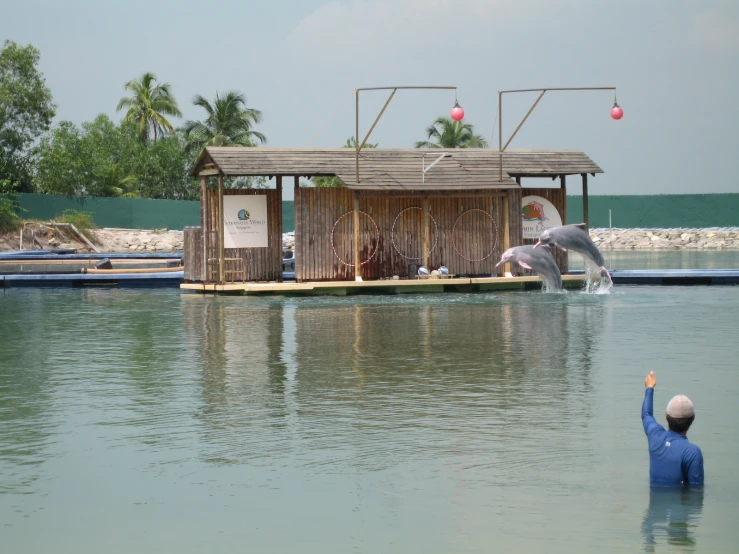 a boy standing near a wooden building in the water