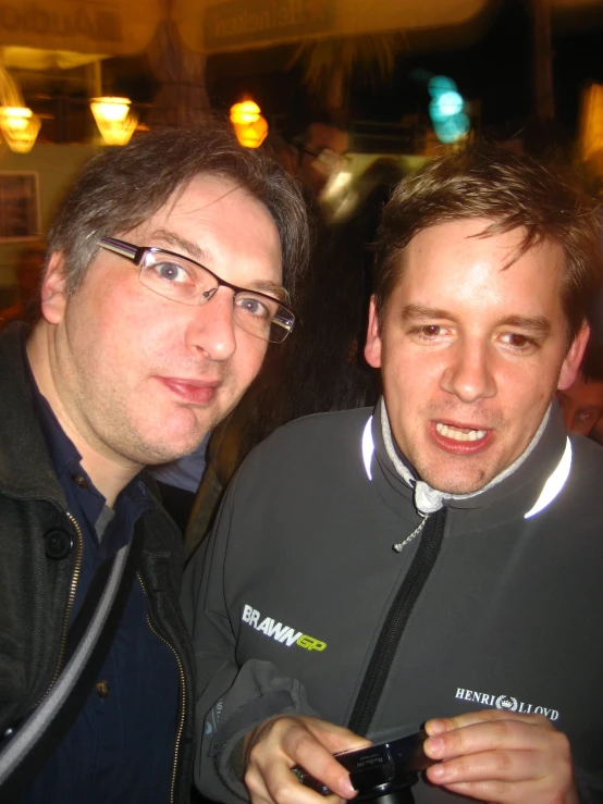 two men posing together for the camera outside