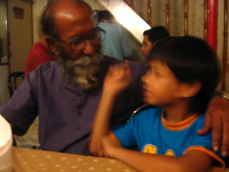 a man with a beard is sitting next to a little boy