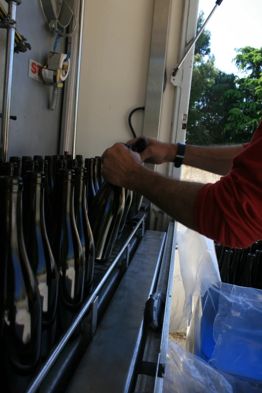 a person holding soing while touching some items on the shelf