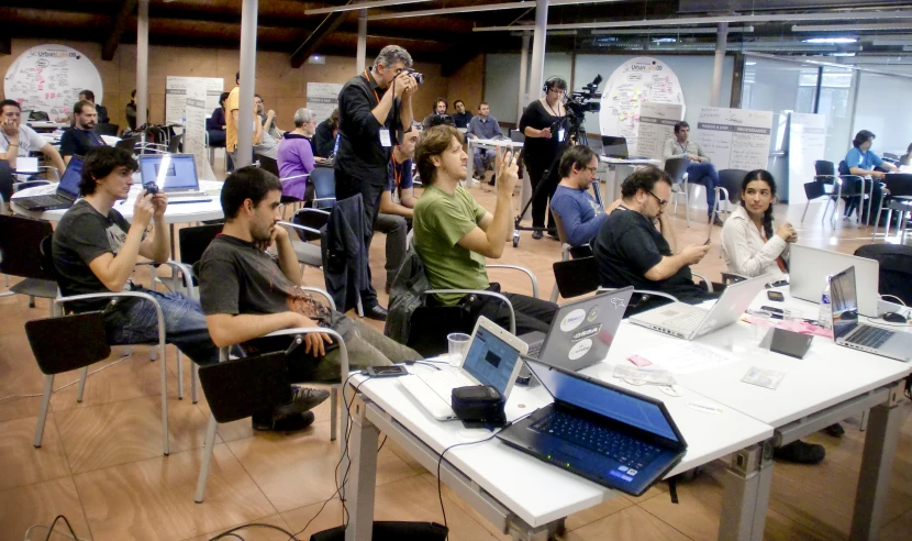 people sitting at tables working with laptops and cell phones