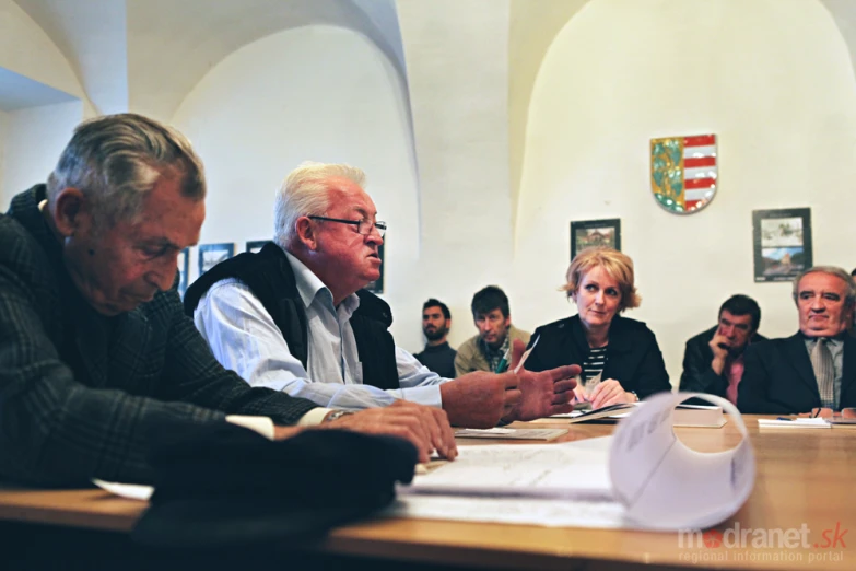 men and women seated at a table talking to each other