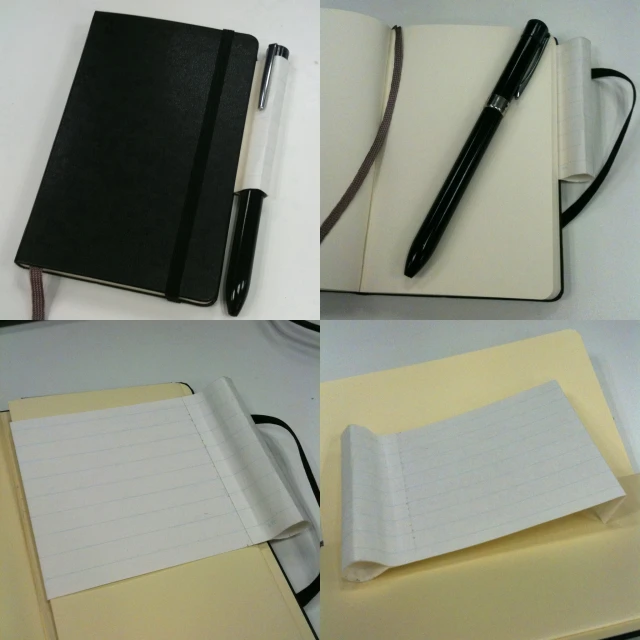 notebooks lined up on a table next to a ballpoint pen
