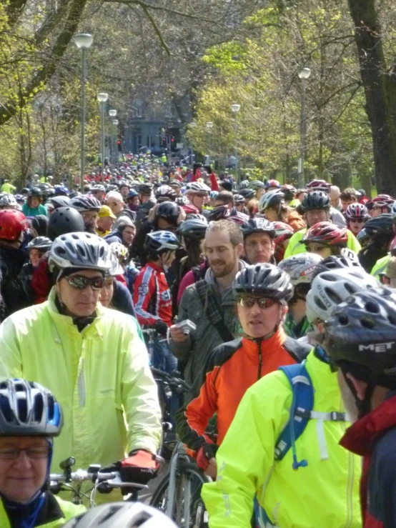 lots of people on bicycles and bicyclists in the middle of the road