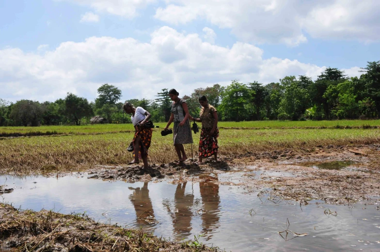 a group of people stand on a muddy field