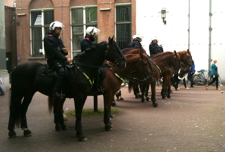 people riding on horses in front of some building