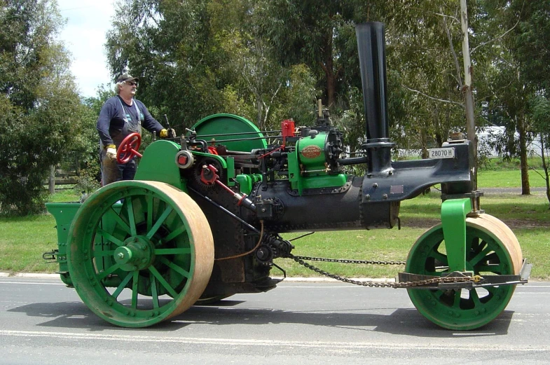 an older man standing in front of a small engine