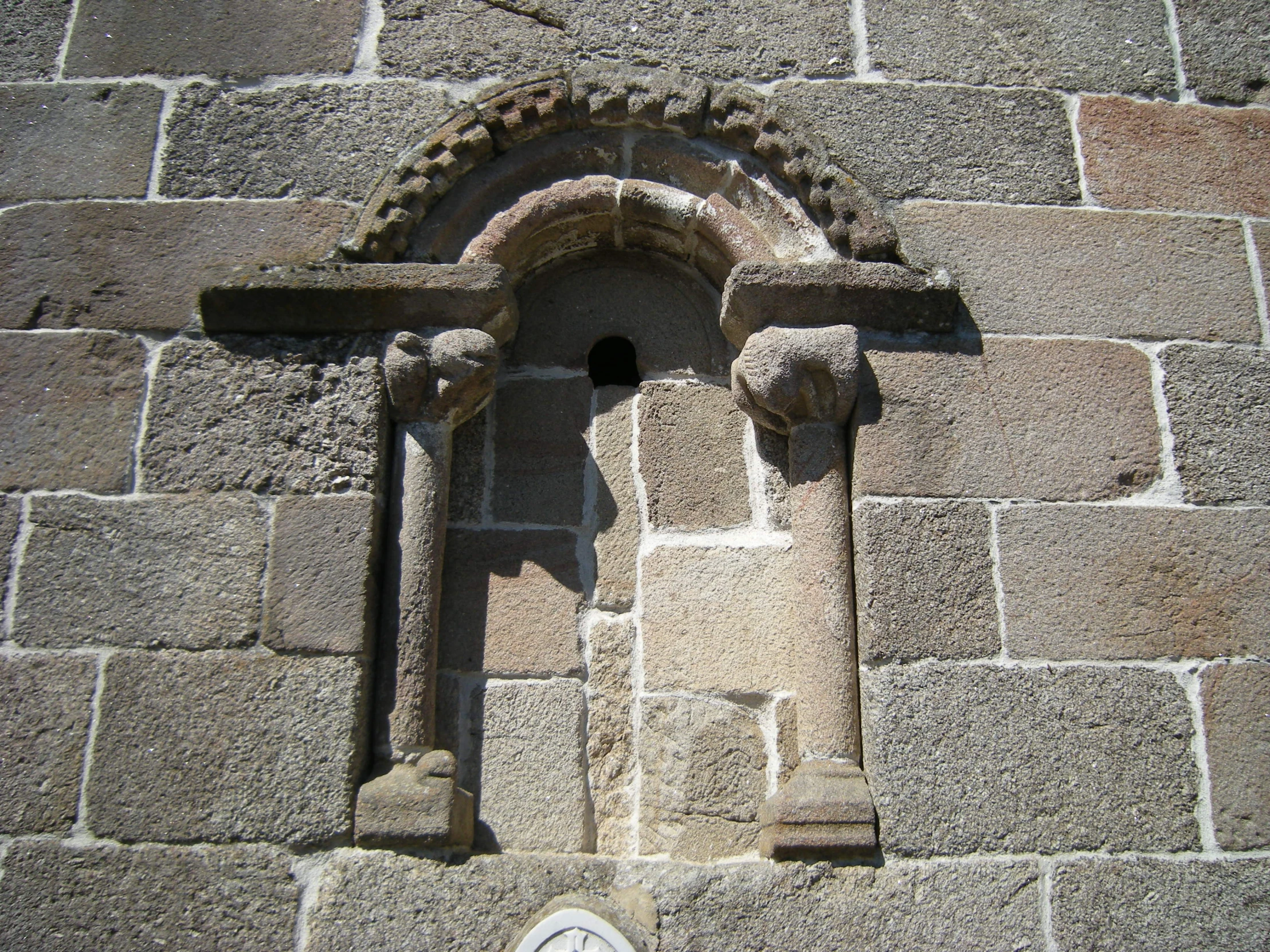 an old building that has a window and a statue