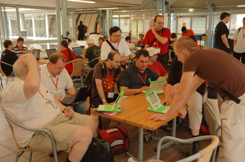 a group of people sitting around a wooden table