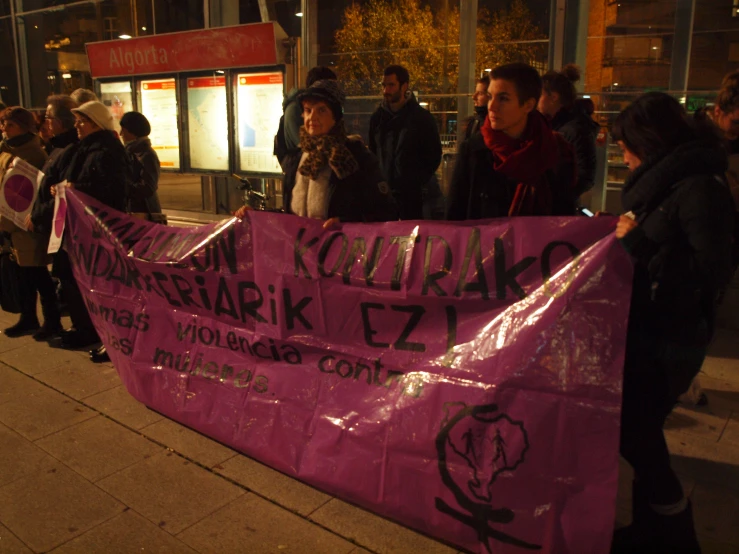 a bunch of people holding up a pink sign