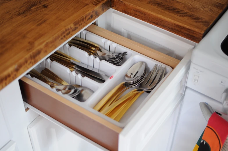 a drawer with various silverware and spoons in it