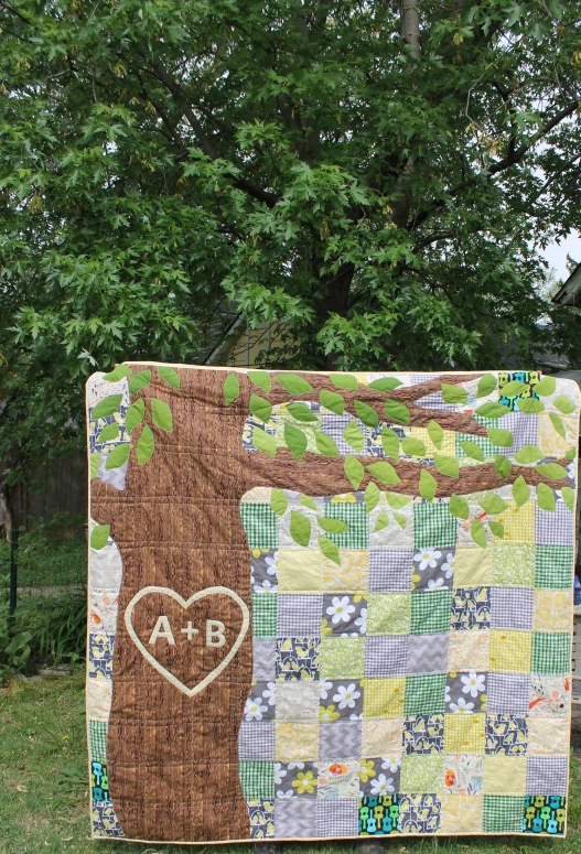 a child's hand made baby quilt hanging from a clothes line