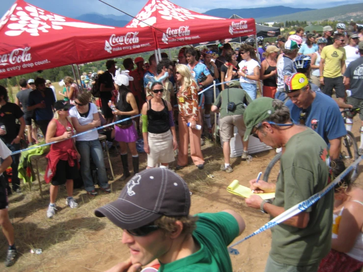 a large group of people standing around a red tent