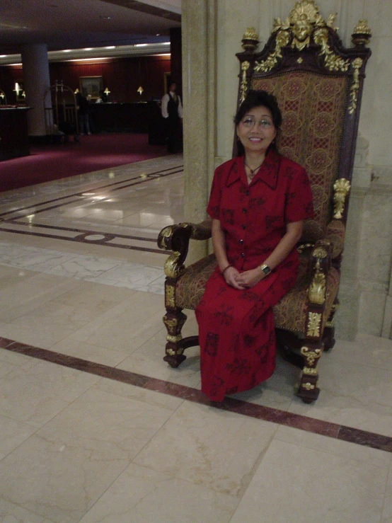 the woman is in a very ornate chair posing for a picture