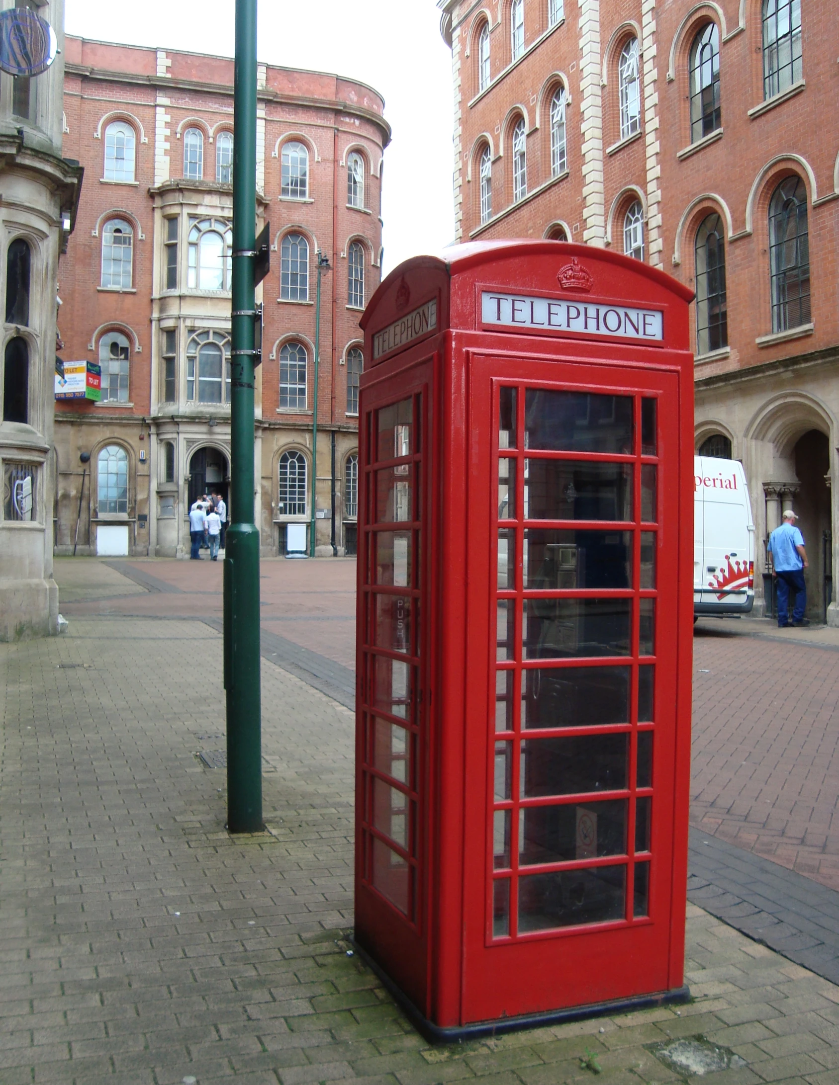 an old fashioned telephone booth next to a street lamp