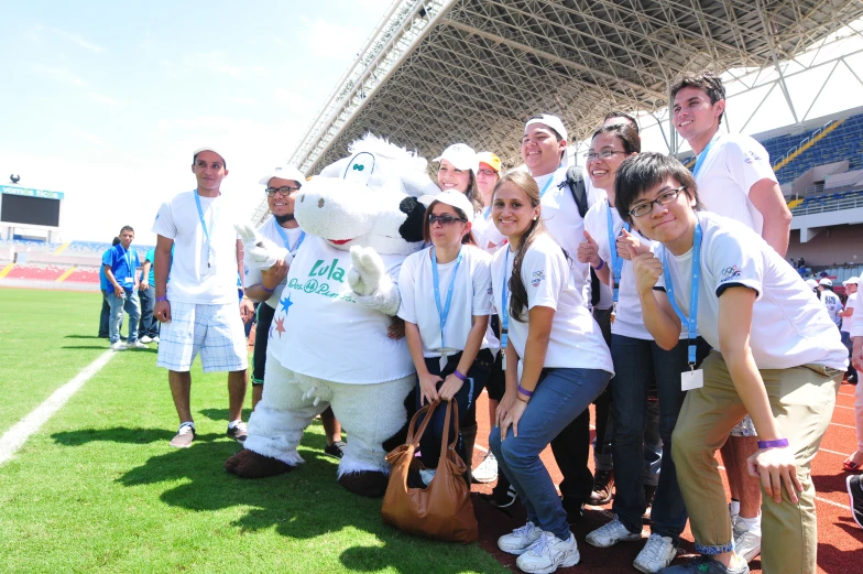 a group of people on a field with a stuffed animal